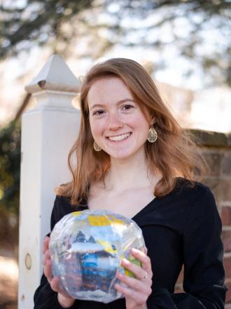 Headshot photo of Education Abroad intern Phoebe holding a globe
