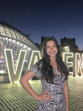 Intern Stephanie Castro in front of the Valencia city sign at night